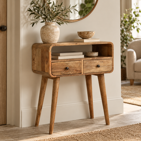 A mid-century modern wooden console table with two drawers and tapered legs, styled in a warm, neutral-toned living room setting.