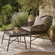 Outdoor wicker easy chair and footstool in a Mediterranean garden setting