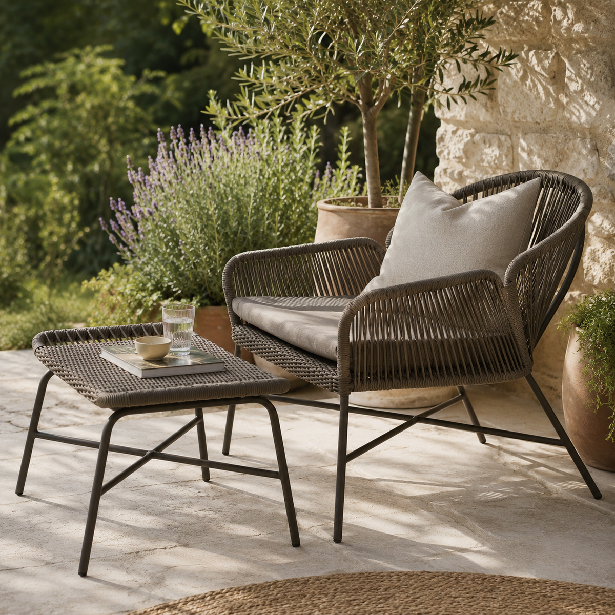 Outdoor wicker easy chair and footstool in a Mediterranean garden setting
