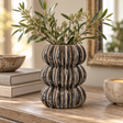 Orsa Grey Stoneware Bubble Vase with a distinctive stacked, rounded form, styled with olive branches on a rustic wooden console.
