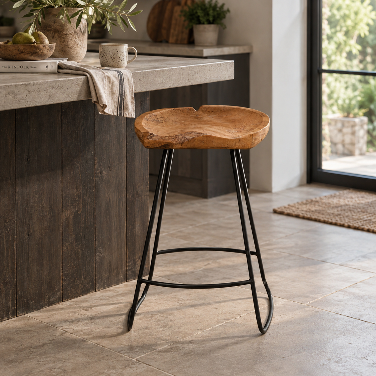 A rustic bar stool with a natural live-edge wood seat and black metal legs, positioned in a modern kitchen setting.