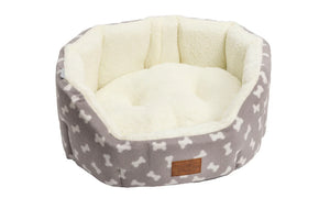 Grey Fleece Bone Print Oval Snuggle Puppy Bed with a cream bone print, cream sherpa lining and leather-look label, on a white background