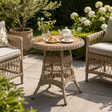 Provence outdoor bistro table with chairs in a garden setting with a teapot and flowers