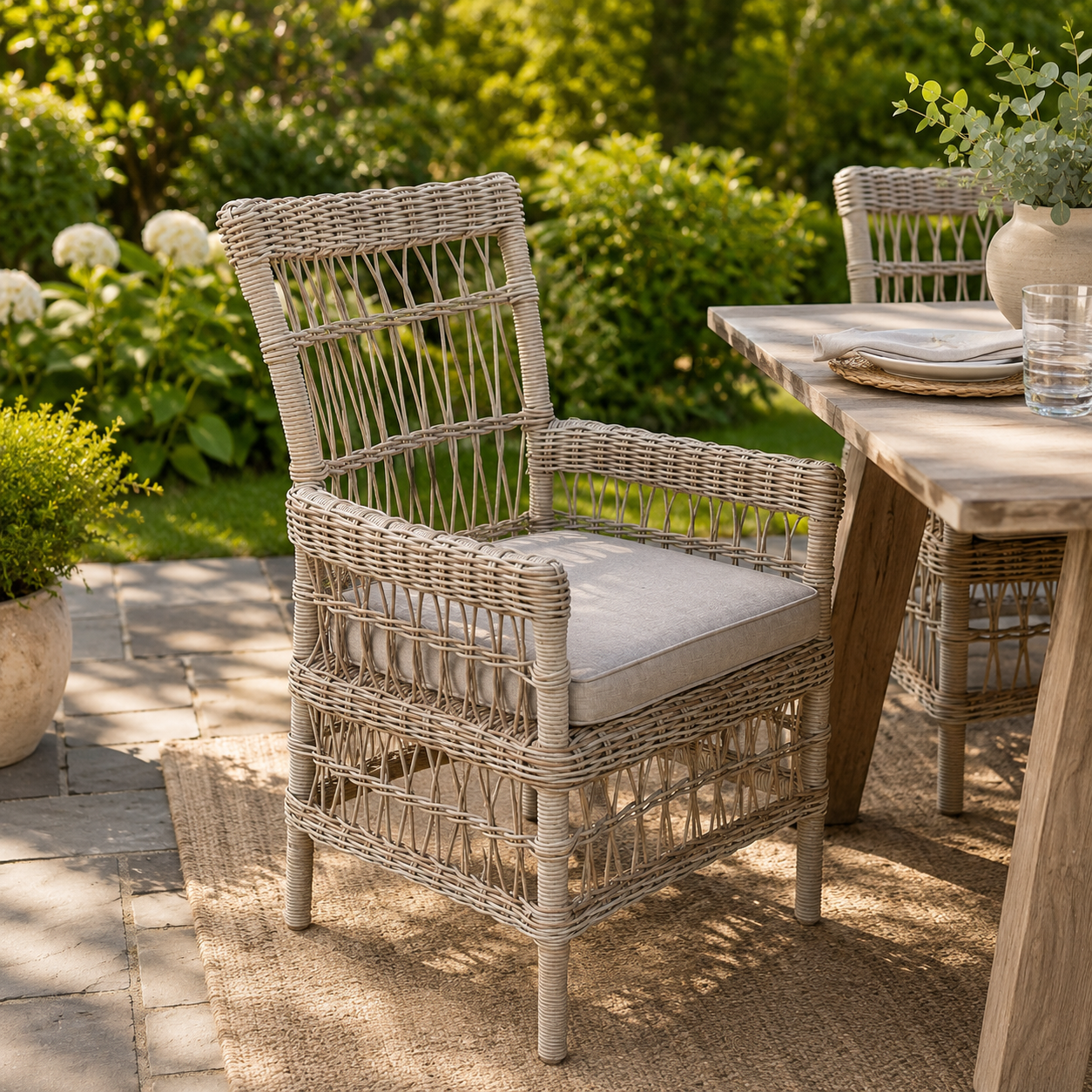 Provence outdoor dining chair in a garden setting with a wooden table and flowers in the background