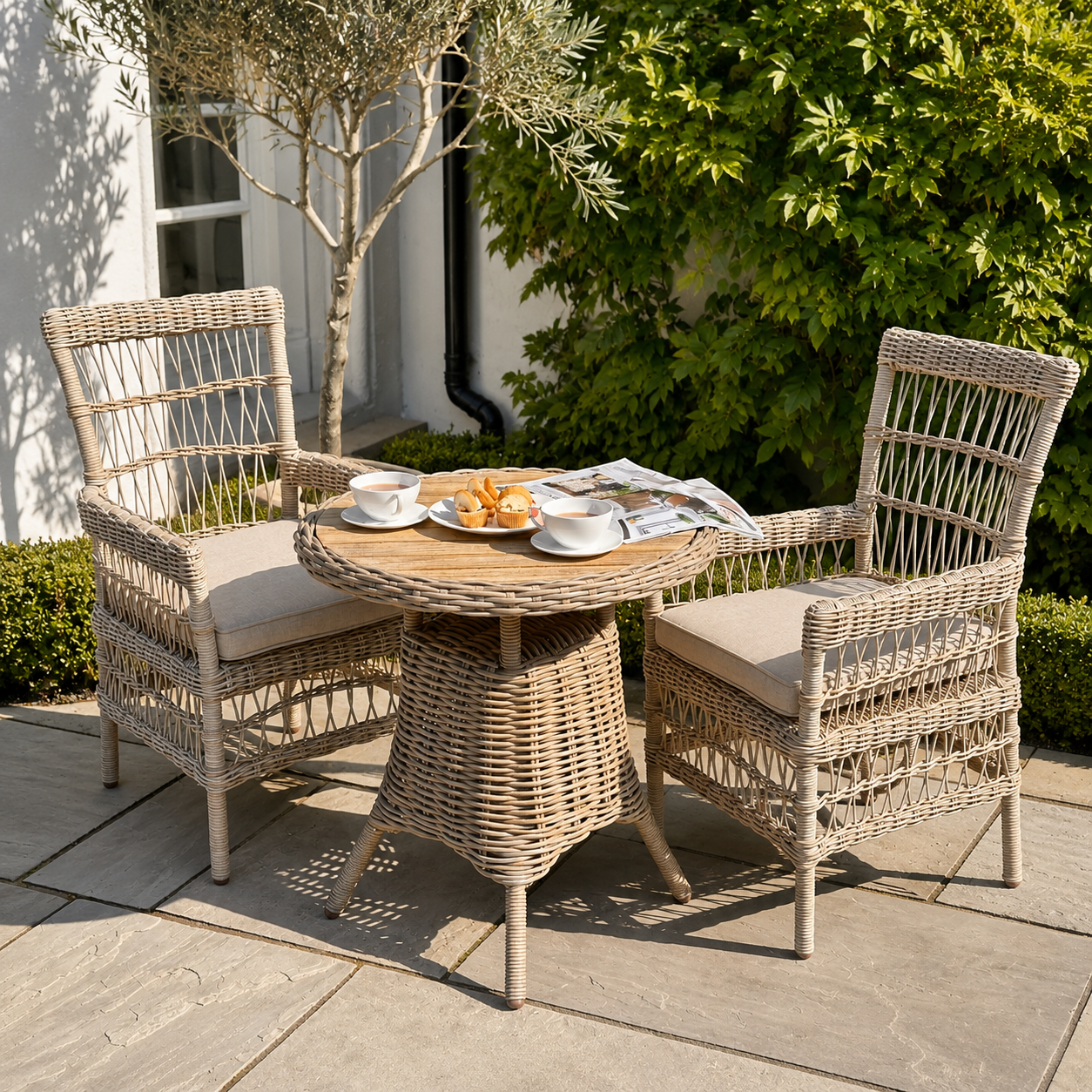 Wicker outdoor furniture set with a small table and two chairs on a patio.