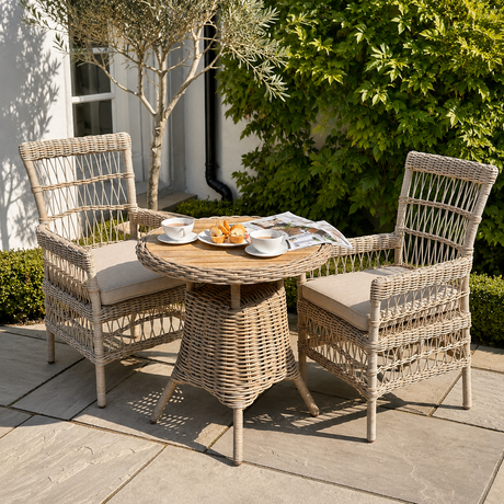 Wicker outdoor furniture set with a small table and two chairs on a patio.