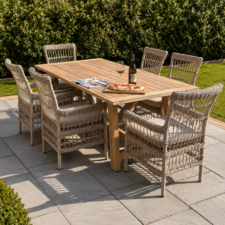 Outdoor dining setup with a wooden table and wicker chairs on a patio.