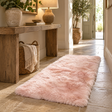 Rectangular Pink Sheepskin Rug on a stone-flagged hallway floor in front of a rustic wooden console and a woven basket