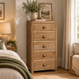 Reclaimed Wood 5 Drawer Chest of Drawers in reclaimed teak with brass cup handles, styled in a bedroom with a jug of greenery and a framed print