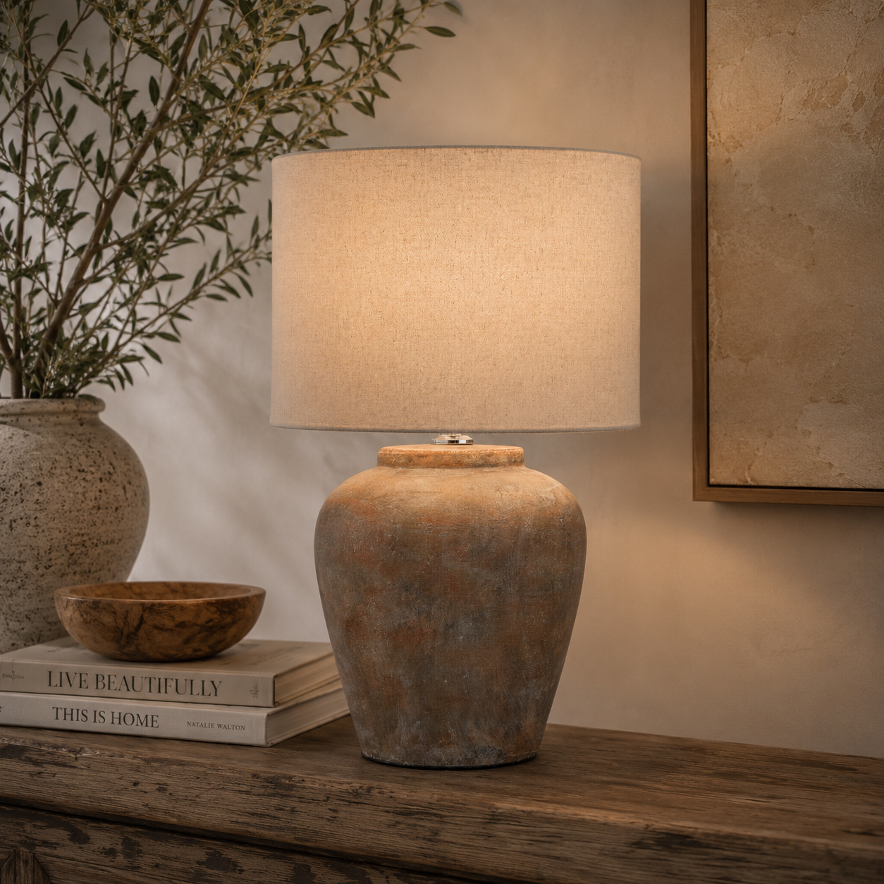 Decorative lamp on a wooden surface with books and a plant in the background