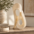 Soren White Marble Effect Large Abstract Loop Sculpture styled on a rustic wooden console table with neutral décor, olive branches, books and a travertine dish.