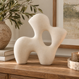 Soren White Marble Effect Organic Sculpture displayed on a rustic wooden console in a warm neutral interior with natural greenery and subtle stone accents.