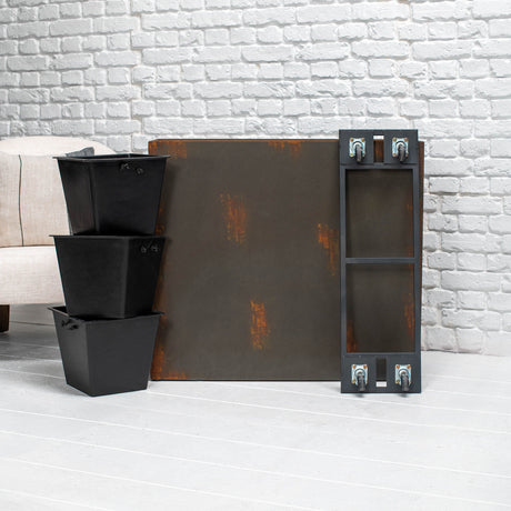 A rustic industrial-style rectangular metal planter with distressed rust patches and a tall narrow side frame with wheels, shown next to three stacked black storage bins against a white brick wall.