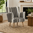 Patterned armchair in a living room setting with a fireplace and plants.