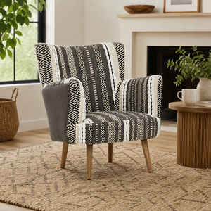 Patterned armchair in a living room setting with a fireplace and plants.