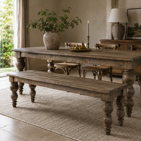 A rustic wooden dining table with matching bench and chairs in a styled dining room setting.