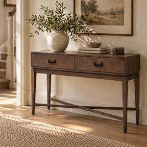 Verona Antique Grey Console Table styled in a hallway with a stoneware vase of olive branches, books and a landscape print above