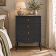 Vienne 4 Drawer Dark Grey Chest of Drawers in a bedroom, styled with a ceramic table lamp, a jug of greenery and books