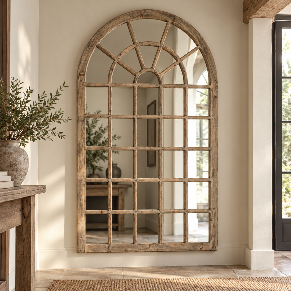 Large Vintage Wall Mirror with an arched window frame in weathered wood, hung in a light hallway beside a stone vase of olive branches