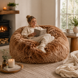 Woman reading a book in a brown sheepskin bean bag chair in a cosy living room.