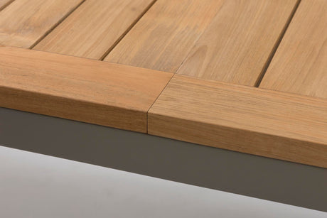 Close-up of a wooden slatted tabletop with a thick natural wood apron and edge, shown against a light gray background.