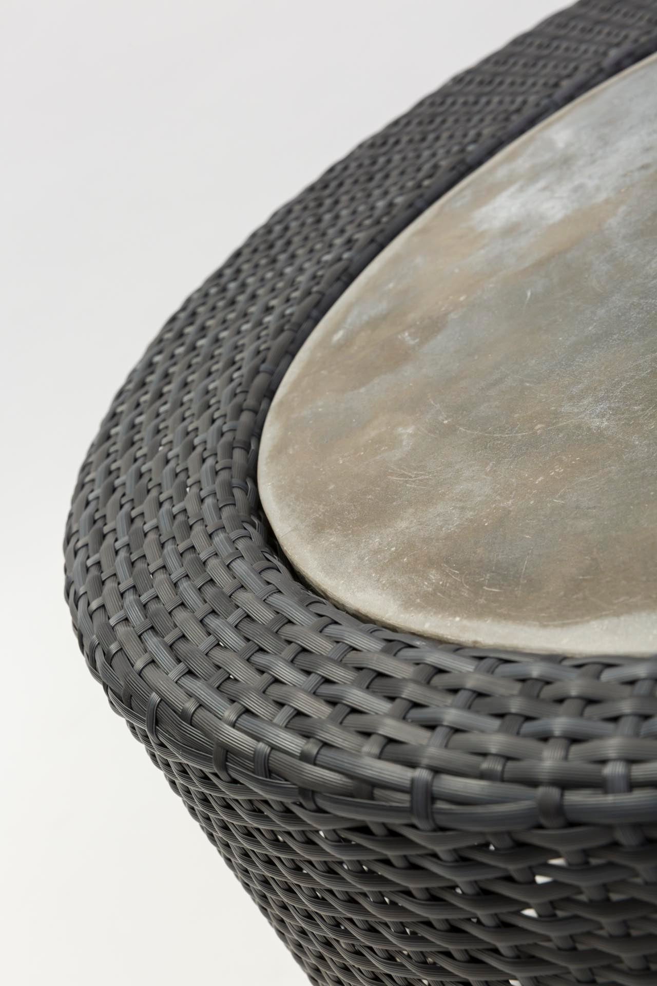 Close-up of a woven coffee table with a stone-like top on a white background