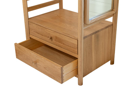 A light oak wood guest open wardrobe with a rectangular mirror on the upper right and an open drawer pulled out on the lower left, shown against a plain white background.