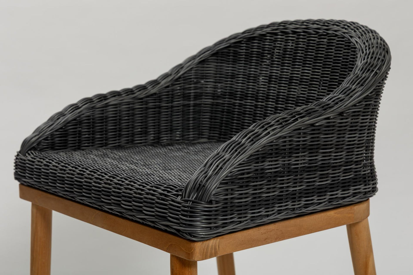 Wicker chair with wooden legs on a plain background