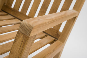 Close-up of a wooden slatted chair showing the armrest and seat slats in a warm natural wood finish against a white background.
