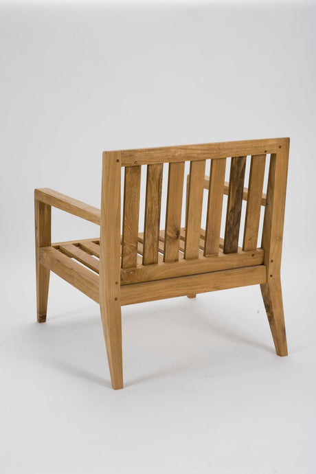 A light natural wood armchair with a slatted backrest and seat, shown from a three-quarters angle against a plain white studio background.