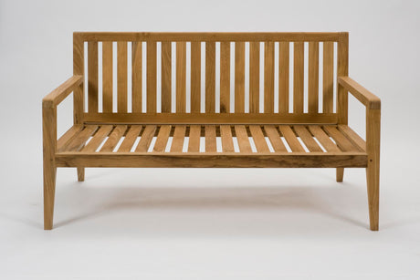 A wooden outdoor bench with a slatted backrest and seat, featuring armrests and a natural oak finish, photographed against a seamless white background.