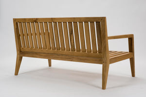 A wooden outdoor bench with a slatted backrest and armrests, shown from a three-quarter angle against a plain white studio background.