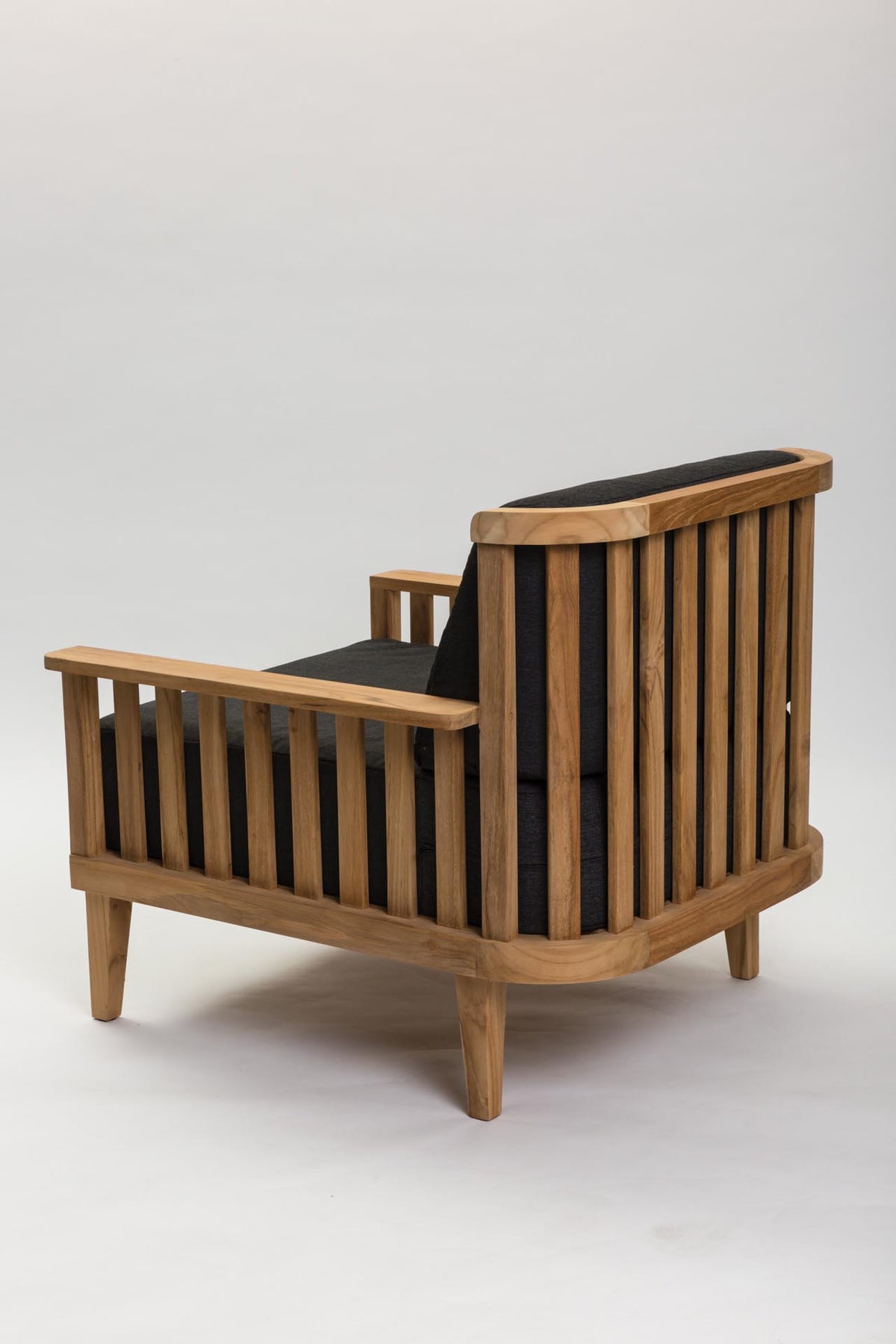 A mid-century modern wooden armchair with a slatted back and sides, upholstered in black fabric, shown from a three-quarters angle on a light gray background.