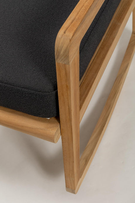 Close-up of a wooden chair with black cushion on a neutral background