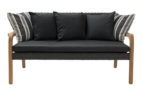 A modern outdoor loveseat with a dark gray woven wicker frame, black seat and back cushions, and light brown wooden legs. It features four throw pillows, including two black pillows and two striped black-and-white pillows, shown against a plain white background.