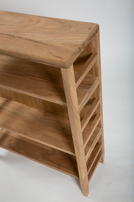 A close-up of a light brown wooden shelving unit with a slatted side panel and three open shelves, photographed against a plain light gray background.