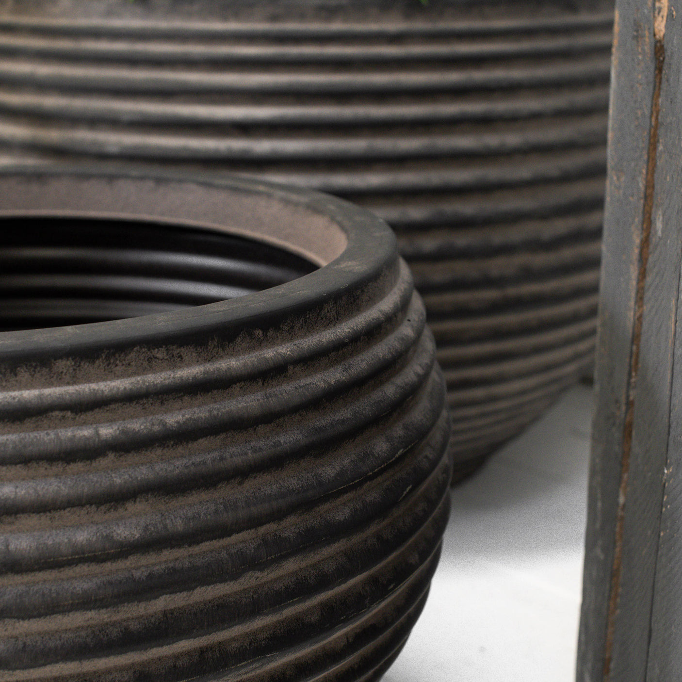 Close up of two dark brown ribbed planters